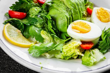 Salata avokado, haşlanmış yumurta, domates, yeşil yaprak marul, sebze tabağı taze gurme yemek arkaplan masanın üzerinde rustik yemek üst görünüm fotokopi uzay vejetaryen gıda