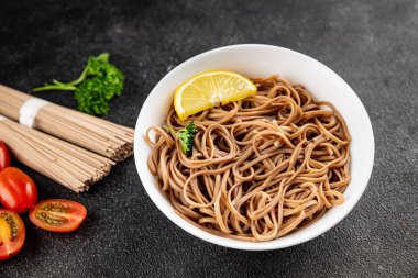 Karabuğday erişteli soba bir kâse taze Asya mutfağı masada rustik yiyecekler üst görünümde fotokopi alanı