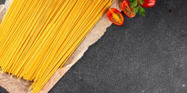 Spagetti makarnası çiğ buğday taze yemek masada rustik gıda üst görünüm fotokopi uzay gıda arka planı