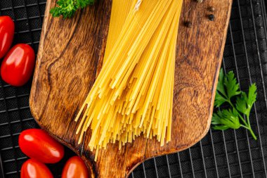 Spagetti makarnası çiğ buğday taze yemek masada rustik gıda üst görünüm fotokopi uzay gıda arka planı