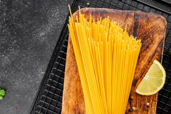 Spagetti makarnası çiğ buğday taze yemek masada rustik gıda üst görünüm fotokopi uzay gıda arka planı