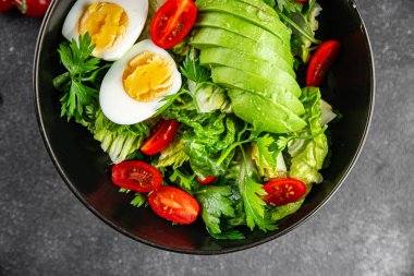 Avokado salatası, haşlanmış yumurta, domates, yeşil yaprak, marul, sebze yemeği taze lezzetli gurme yemek arka planda masanın üstünde rustik yiyecekler fotokopi alanı keto ve paleo diyeti vejetaryen yemekleri