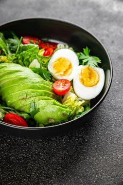 Avokado salatası, haşlanmış yumurta, domates, yeşil yaprak, marul, sebze yemeği taze lezzetli gurme yemek arka planda masanın üstünde rustik yiyecekler fotokopi alanı keto ve paleo diyeti vejetaryen yemekleri