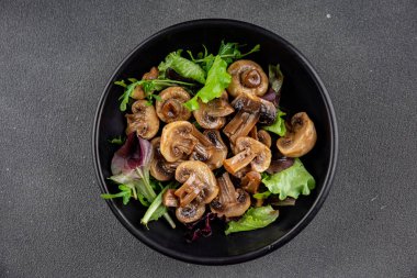 Şampiyon mantarlar salata aperatifi taze gurme yemek arkaplanı masadaki rustik yiyecekler fotokopi alanı vejetaryen yemekleri.