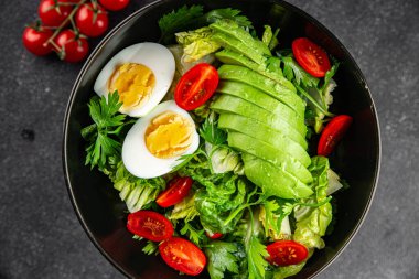 Avokado salatası, haşlanmış yumurta, domates, yeşil yaprak, marul, sebze yemeği taze lezzetli gurme yemek arka planda masanın üstünde rustik yiyecekler fotokopi alanı keto ve paleo diyeti vejetaryen yemekleri