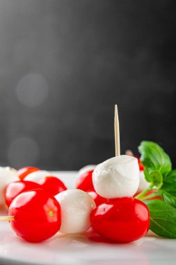 Caprese salatası kanape domates ve mozzarella, fesleğen iştah açıcı sebze taze gurme yemek arkaplanı masa rustik gıda üst görünümü fotokopi alanı