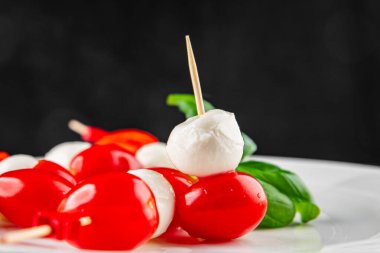 Caprese salatası kanape domates ve mozzarella, fesleğen iştah açıcı sebze taze gurme yemek arkaplanı masa rustik gıda üst görünümü fotokopi alanı