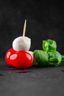 Caprese salatası kanape domates ve mozzarella, fesleğen iştah açıcı sebze taze gurme yemek arkaplanı masa rustik gıda üst görünümü fotokopi alanı