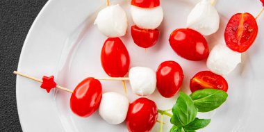 Caprese salatası kanape domates ve mozzarella, fesleğen iştah açıcı sebze taze gurme yemek arkaplanı masa rustik gıda üst görünümü fotokopi alanı