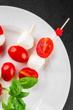 Caprese salatası kanape domates ve mozzarella, fesleğen iştah açıcı sebze taze gurme yemek arkaplanı masa rustik gıda üst görünümü fotokopi alanı