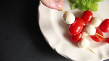 Caprese salatası kanape domates ve mozzarella, fesleğen iştah açıcı sebze taze gurme yemek arkaplanı masa rustik gıda üst görünümü fotokopi alanı