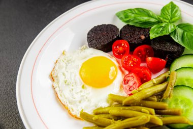 İngiliz kahvaltısı sahanda yumurta, kara puding, sebzeler, fasulye taze gurme yemek arkaplanı masanın kırsal kesiminde fotokopi alanı.