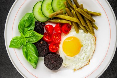 İngiliz kahvaltısı sahanda yumurta, kara puding, sebzeler, fasulye taze gurme yemek arkaplanı masanın kırsal kesiminde fotokopi alanı.