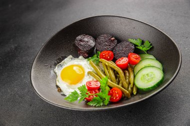 İngiliz kahvaltısı sahanda yumurta, kara puding, sebzeler, fasulye taze gurme yemek arkaplanı masanın kırsal kesiminde fotokopi alanı.