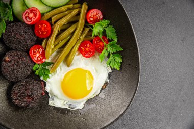 İngiliz kahvaltısı sahanda yumurta, kara puding, sebzeler, fasulye taze gurme yemek arkaplanı masanın kırsal kesiminde fotokopi alanı.