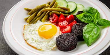 İngiliz kahvaltısı sahanda yumurta, kara puding, sebzeler, fasulye taze gurme yemek arkaplanı masanın kırsal kesiminde fotokopi alanı.