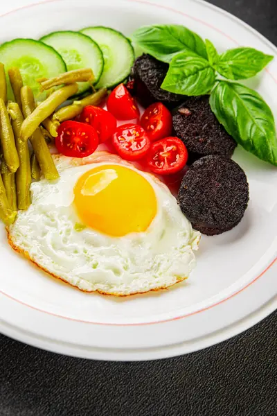 İngiliz kahvaltısı sahanda yumurta, kara puding, sebzeler, fasulye taze gurme yemek arkaplanı masanın kırsal kesiminde fotokopi alanı.