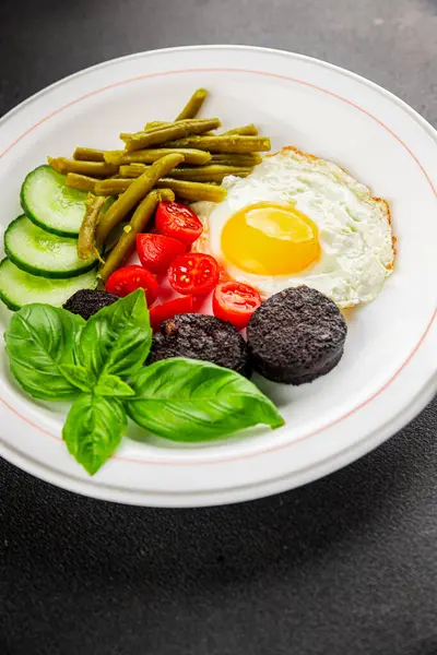 İngiliz kahvaltısı sahanda yumurta, kara puding, sebzeler, fasulye taze gurme yemek arkaplanı masanın kırsal kesiminde fotokopi alanı.