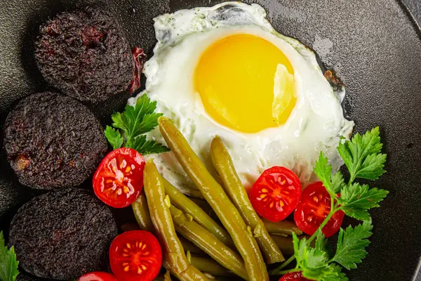 İngiliz kahvaltısı sahanda yumurta, kara puding, sebzeler, fasulye taze gurme yemek arkaplanı masanın kırsal kesiminde fotokopi alanı.