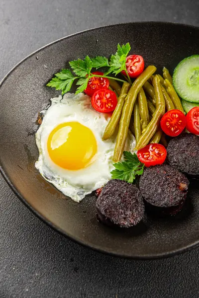 İngiliz kahvaltısı sahanda yumurta, kara puding, sebzeler, fasulye taze gurme yemek arkaplanı masanın kırsal kesiminde fotokopi alanı.