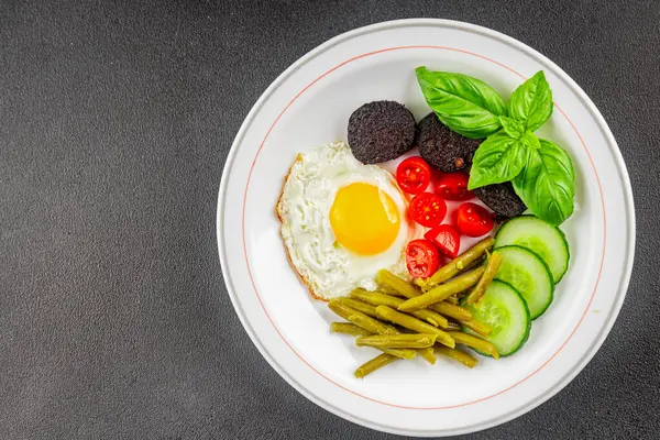 İngiliz kahvaltısı sahanda yumurta, kara puding, sebzeler, fasulye taze gurme yemek arkaplanı masanın kırsal kesiminde fotokopi alanı.