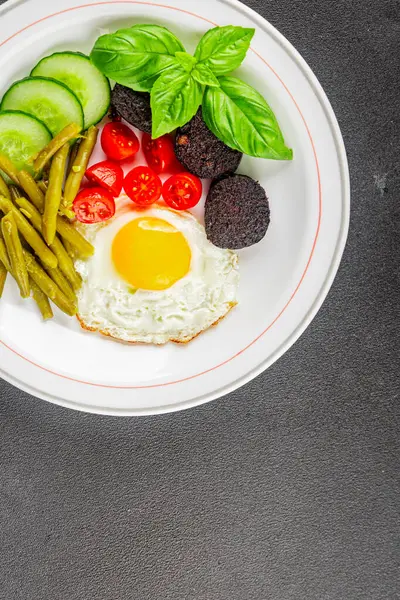 İngiliz kahvaltısı sahanda yumurta, kara puding, sebzeler, fasulye taze gurme yemek arkaplanı masanın kırsal kesiminde fotokopi alanı.