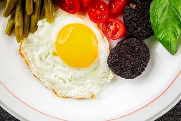 İngiliz kahvaltısı sahanda yumurta, kara puding, sebzeler, fasulye taze gurme yemek arkaplanı masanın kırsal kesiminde fotokopi alanı.