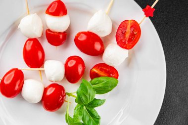 Caprese kanape domates ve mozzarella, fesleğen aperatifi sebze salatası taze gurme yemek arkaplanı masa rustik yemekler üst görünüm uzay keto ve paleo diyet vejetaryen gıda fotokopisi
