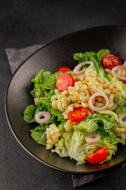 Makarna salatası yeşil yaprak marul, domates, makarna, soğan taze lezzetli gurme yemek arkaplan masa üzerinde rustik gıda üst görünüm fotokopi alanı keto ve paleo diyet vegan ve vejetaryen gıda