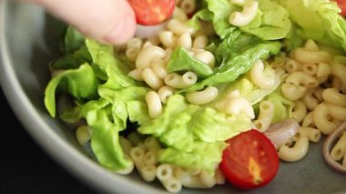 Makarna salatası yeşil yaprak marul, domates, makarna, soğan taze lezzetli gurme yemek arkaplan masa üzerinde rustik gıda üst görünüm fotokopi alanı keto ve paleo diyet vegan ve vejetaryen gıda