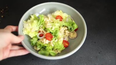 Makarna salatası yeşil yaprak marul, domates, makarna, soğan taze lezzetli gurme yemek arkaplan masa üzerinde rustik gıda üst görünüm fotokopi alanı keto ve paleo diyet vegan ve vejetaryen gıda