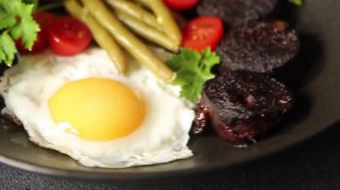 İngiliz kahvaltısı sahanda yumurta, kara puding, sebzeler, fasulye taze gurme yemek arkaplanı masanın kırsal kesiminde fotokopi alanı.