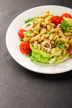 Fasulye salatası yeşil yaprak marul, domates, soğan tabağı taze lezzetli gurme yemek arkaplan masa üzerinde rustik gıda üst görünüm fotokopi alanı keto ve paleo diyet vegan ve vejetaryen gıda