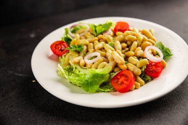 Fasulye salatası yeşil yaprak marul, domates, soğan tabağı taze lezzetli gurme yemek arkaplan masa üzerinde rustik gıda üst görünüm fotokopi alanı keto ve paleo diyet vegan ve vejetaryen gıda