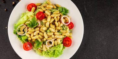 Fasulye salatası yeşil yaprak marul, domates, soğan tabağı taze lezzetli gurme yemek arkaplan masa üzerinde rustik gıda üst görünüm fotokopi alanı keto ve paleo diyet vegan ve vejetaryen gıda