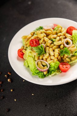 Fasulye salatası yeşil yaprak marul, domates, soğan tabağı taze lezzetli gurme yemek arkaplan masa üzerinde rustik gıda üst görünüm fotokopi alanı keto ve paleo diyet vegan ve vejetaryen gıda