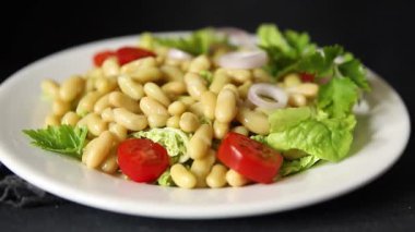 Fasulye salatası yeşil yaprak marul, domates, soğan tabağı taze lezzetli gurme yemek arkaplan masa üzerinde rustik gıda üst görünüm fotokopi alanı keto ve paleo diyet vegan ve vejetaryen gıda