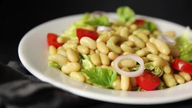 Fasulye salatası yeşil yaprak marul, domates, soğan tabağı taze lezzetli gurme yemek arkaplan masa üzerinde rustik gıda üst görünüm fotokopi alanı keto ve paleo diyet vegan ve vejetaryen gıda