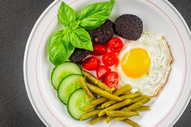 İngiliz kahvaltısı sahanda yumurta, kara puding, sebzeler, fasulye taze gurme yemek arkaplanı masanın kırsal kesiminde fotokopi alanı.