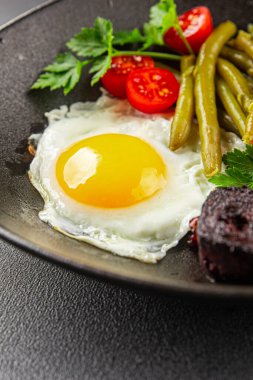 İngiliz kahvaltısı sahanda yumurta, kara puding, sebzeler, fasulye taze gurme yemek arkaplanı masanın kırsal kesiminde fotokopi alanı.