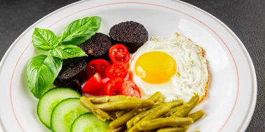 İngiliz kahvaltısı sahanda yumurta, kara puding, sebzeler, fasulye taze gurme yemek arkaplanı masanın kırsal kesiminde fotokopi alanı.