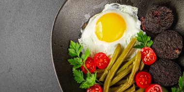 İngiliz kahvaltısı sahanda yumurta, kara puding, sebzeler, fasulye taze gurme yemek arkaplanı masanın kırsal kesiminde fotokopi alanı.