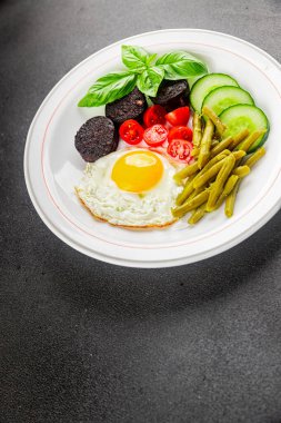 İngiliz kahvaltısı sahanda yumurta, kara puding, sebzeler, fasulye taze gurme yemek arkaplanı masanın kırsal kesiminde fotokopi alanı.