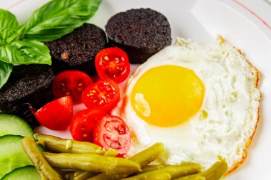 İngiliz kahvaltısı sahanda yumurta, kara puding, sebzeler, fasulye taze gurme yemek arkaplanı masanın kırsal kesiminde fotokopi alanı.