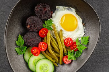 İngiliz kahvaltısı sahanda yumurta, kara puding, sebzeler, fasulye taze gurme yemek arkaplanı masanın kırsal kesiminde fotokopi alanı.
