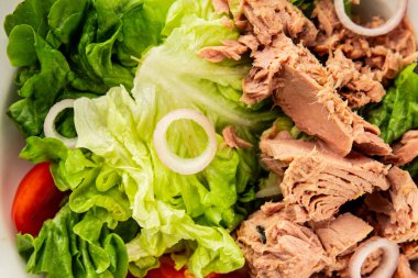 Ton balığı salatası yeşil marul, konserve ton balığı, domates taze lezzetli gurme yemek arkaplanı masanın üstünde rustik yemekler fotokopi alanı keto ve paleo diyet vejetaryen diyeti.