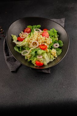 Makarna salatası yeşil yaprak marul, domates, makarna, soğan taze lezzetli gurme yemek arkaplan masa üzerinde rustik gıda üst görünüm fotokopi alanı keto ve paleo diyet vegan ve vejetaryen gıda