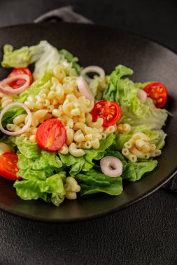 Makarna salatası yeşil yaprak marul, domates, makarna, soğan taze lezzetli gurme yemek arkaplan masa üzerinde rustik gıda üst görünüm fotokopi alanı keto ve paleo diyet vegan ve vejetaryen gıda