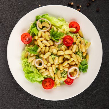 Fasulye salatası yeşil yaprak marul, domates, soğan tabağı taze lezzetli gurme yemek arkaplan masa üzerinde rustik gıda üst görünüm fotokopi alanı keto ve paleo diyet vegan ve vejetaryen gıda