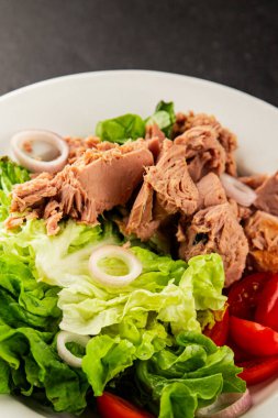 Ton balığı salatası yeşil marul, konserve ton balığı, domates taze lezzetli gurme yemek arkaplanı masanın üstünde rustik yemekler fotokopi alanı keto ve paleo diyet vejetaryen diyeti.